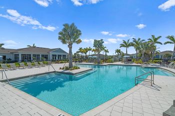 a large swimming pool with palm trees in front of a building